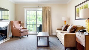 A hotel room with a fireplace, a sofa, a coffee table, and a TV. - Franconia Notch State Park - South Mountain Resort (Lincoln)