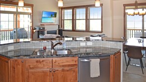 A kitchen with wooden cabinets, a granite countertop, and a built-in dishwasher. - Gorgeous luxury top floor condo! Stunning Mountain Views! Private decks! Garage  (Fraser)
