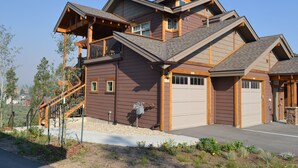 A two-story house with a balcony, a garage, and a staircase leading to the upper level. - Gorgeous luxury top floor condo! Stunning Mountain Views! Private decks! Garage  (Fraser)