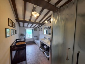 A narrow hallway with a wooden ceiling, a window with a view, a sink, and a refrigerator. -  Pasqui Villas Historic Villa La Consuma San Giovanni D'Asso-Italy (SAN GIOVANNI D'ASSO)