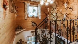 A wooden interior with a staircase, a chandelier, and antler decorations. - Nice apartment for 6 guests with WIFI, TV and balcony (Bramberg Am Wildkogel)