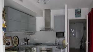 A modern kitchen with stainless steel appliances, white cabinetry, and a central island.