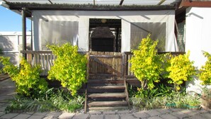 A house with a covered porch, a wooden gate, and a small staircase leading to the entrance. - Princess Vacation Home (Richwood)