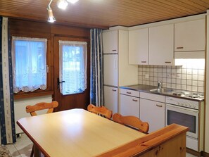 Enjoy meals in this cozy kitchen with an oven, dining table, and comfortable chairs.