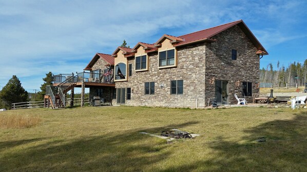 A stone house with a red roof, a covered deck, and a flag. - Georgetown Lake, Discovery and the Pintlers (Anaconda)