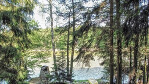 A forested area with a stone structure near a body of water, likely a lake or pond. - Beautiful private villa for 6 guests with WIFI, A/C, TV, patio and pets allowed (Malý Ratmírov)