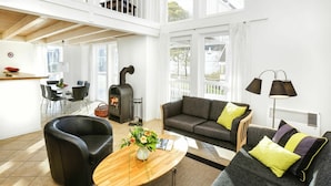 A spacious living room with a fireplace, a dining area, and a view of the outdoors.