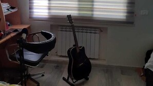 A room with a radiator, a guitar leaning against the wall, a chair, and a desk with a bookshelf. - The Chedy Home (Ariana)
