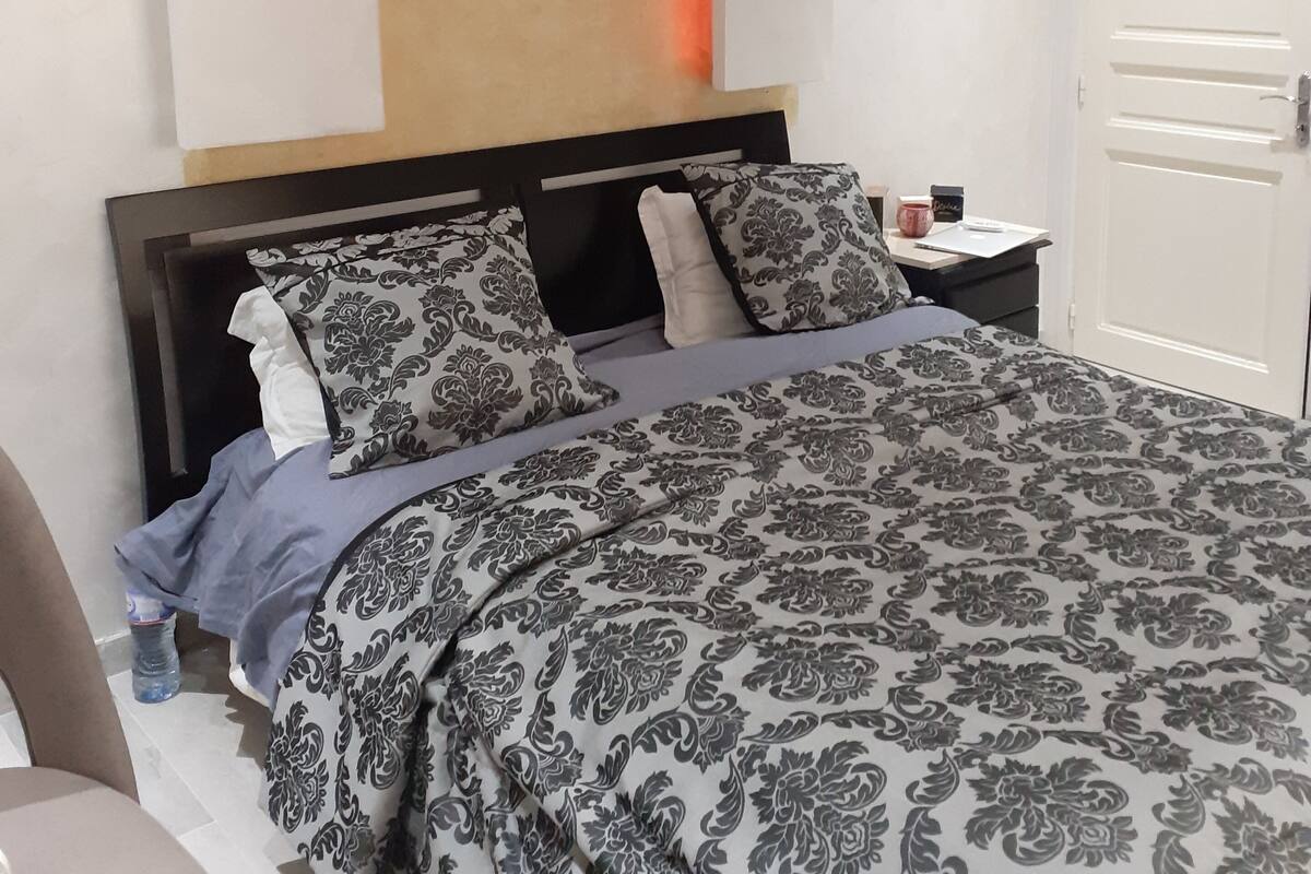 Une chambre à coucher avec un lit, une table de chevet et une porte.