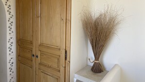A wooden door with a decorative panel and a vase with dried plants on a small table. - les-pepites-de-Badou.fr present LA GRAVIERE -Classified 4 *- (Le Barroux)