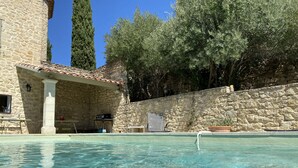 A stone building with a pool, outdoor seating, and a stone wall. - les-pepites-de-Badou.fr present LA GRAVIERE -Classified 4 *- (Le Barroux)