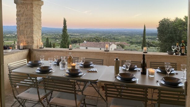 An outdoor dining area with tables set for two, candles, and bottles of wine, overlooking a scenic landscape. - les-pepites-de-Badou.fr present LA GRAVIERE -Classified 4 *- (Le Barroux)