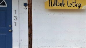 A blue door with the number 131 and a yellow sign that reads "Hillside Cottage". - Hillside Cottage in Beautiful Downtown Hermann (Hermann)