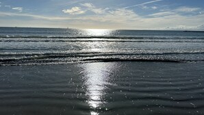 Een strand met golven en een heldere lucht.