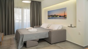 Un dormitorio moderno con una cama, cortinas grises, un cuadro de un paisaje urbano y una mesita de noche con una lámpara.
