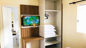 A bedroom with a TV on the wall, a wardrobe, and a bed with a floral bedspread. - Lacqua di Roma Hotel with Water Park and Flats complete with Kitchen (Caldas Novas)