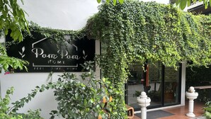 L’entrée d’un immeuble, avec une pancarte indiquant : « Poni Poni HOME, l’impression d’être chez soi ».