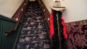 A staircase with patterned carpet and wooden banisters. - Red Garter Inn (Williams)