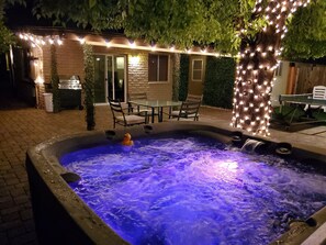A hot tub with two ducks, surrounded by outdoor furniture and string lights. - Pet friendly Huge Paved Patio w/Spa: Old Town Scottsdale (Scottsdale)