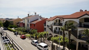 Eine Wohnstraße mit mehrstöckigen Häusern, blauem Himmel und parkenden Autos.