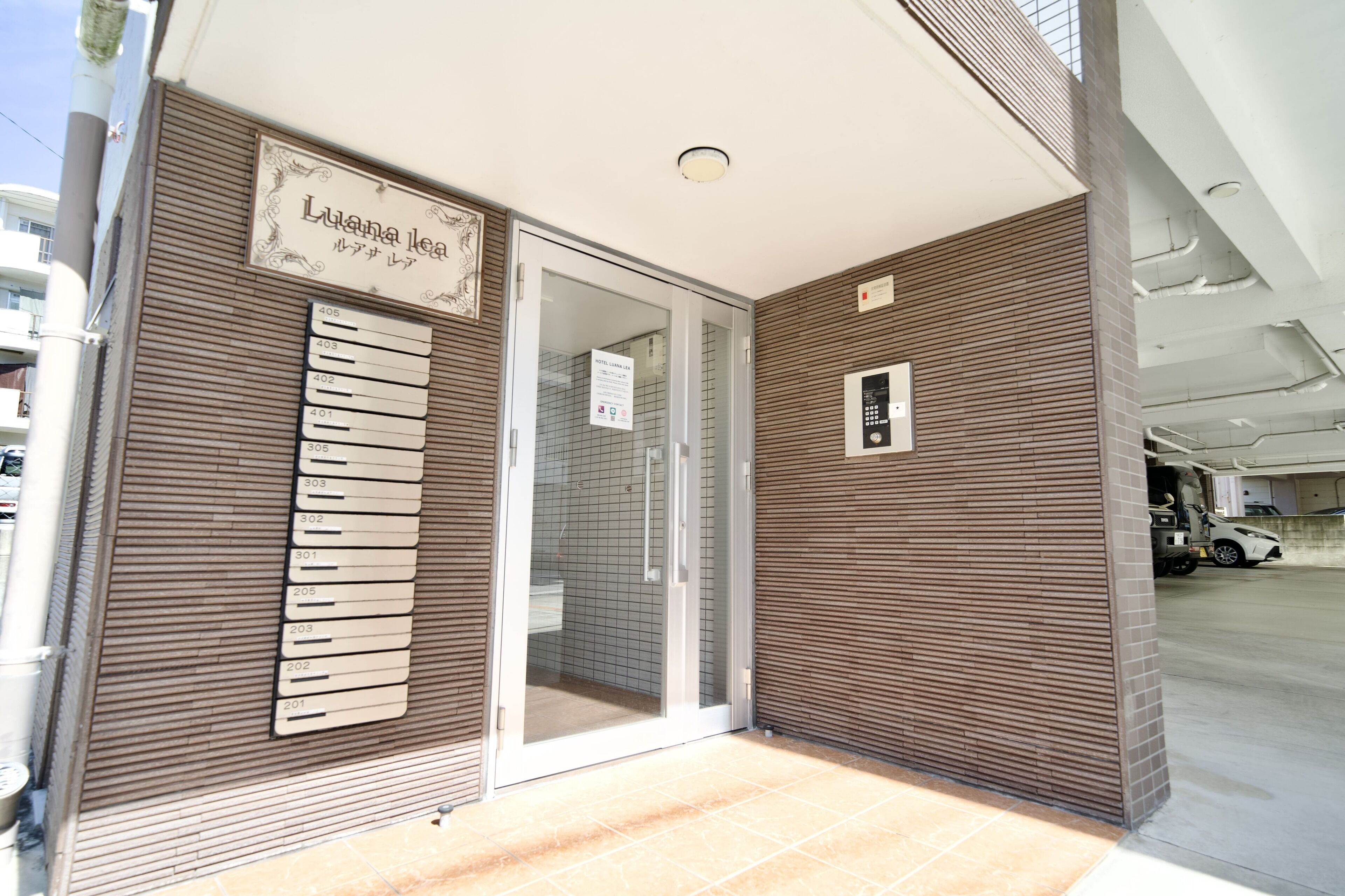 A hotel entrance with a sign indicating room numbers and a name.
