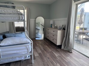 A bunk bed room with a wooden floor, a dresser, and a mirror. - Dolphins, Sunsets & Waterfront Living – Heated Pool + Dock & Kayaks Near Beaches (Englewood)