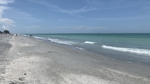 A beach with a wide sandy shore, calm sea, and clear sky. - Dolphins, Sunsets & Waterfront Living – Heated Pool + Dock & Kayaks Near Beaches (Englewood)