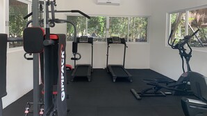 Ein Fitnessstudio mit Cardiogeräten, Krafttrainingsgeräten und Laufbändern.