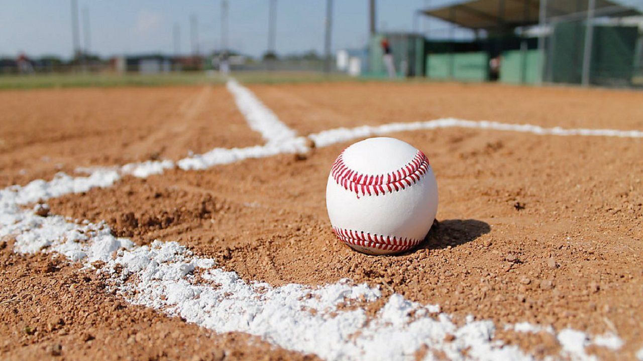 En baseball på en jordbane med hvide kridtstregers markeringer.