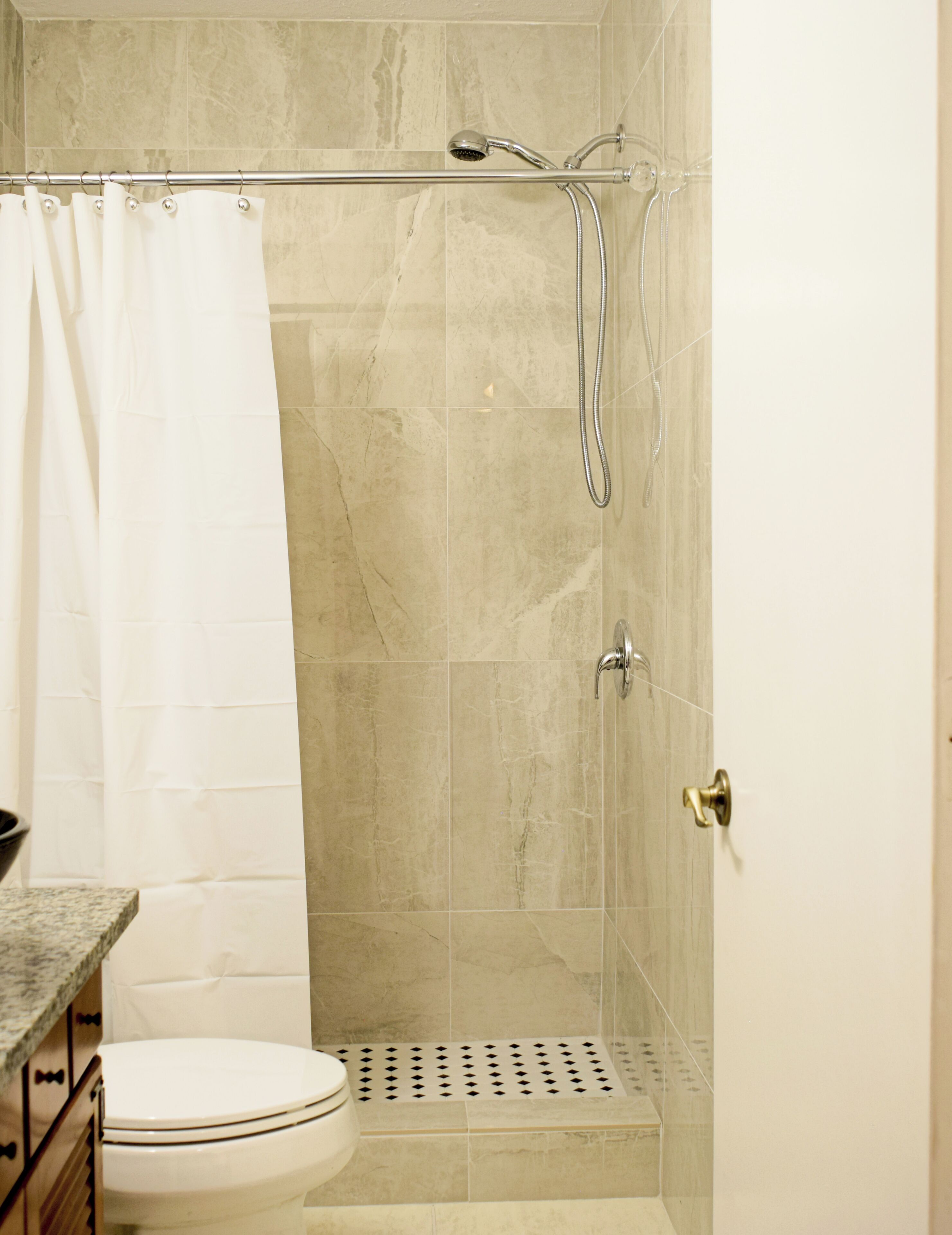 Une salle de bain avec douche, toilettes et lavabo.