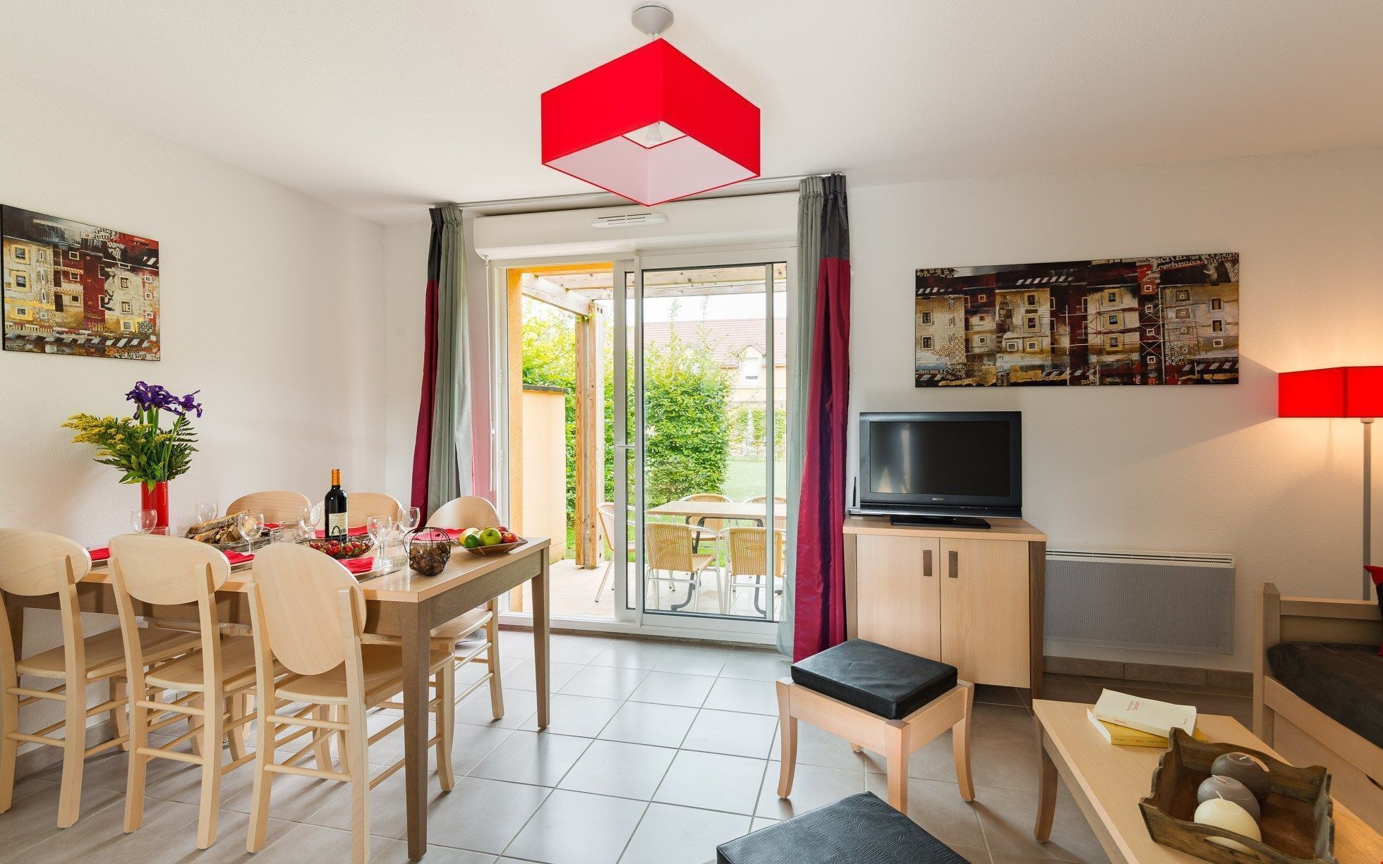 Un salon bien éclairé comprenant un coin repas, un téléviseur et un canapé.