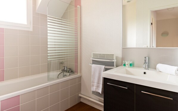 Un baño con una bañera, un lavabo y un espejo.