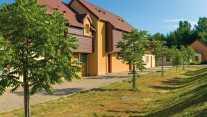 A residential building with a symmetrical facade, a central entrance, and a well-maintained lawn.