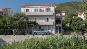 A two-story building with a red-tiled roof, white walls, and balconies.