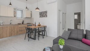 A modern apartment with a kitchen, dining area, and living room.