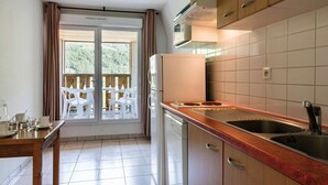 A kitchen with a view to a balcony, a sink, a microwave, and a dishwasher.