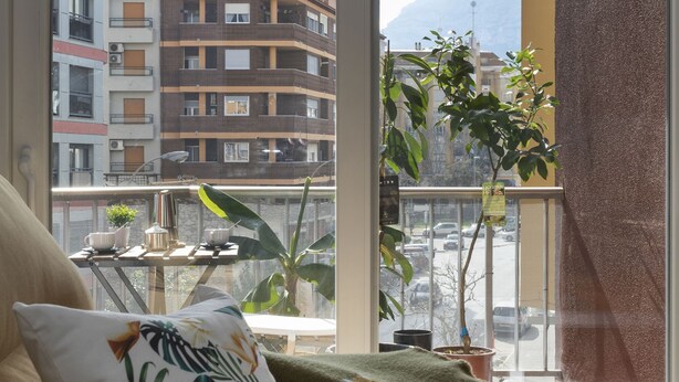 Ein Balkon mit Blick auf Gebäude und einen Berg.