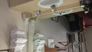 A bathroom with a mirror, towel rack, and a sink. - Spinning Wheel Inn Branson (Branson)
