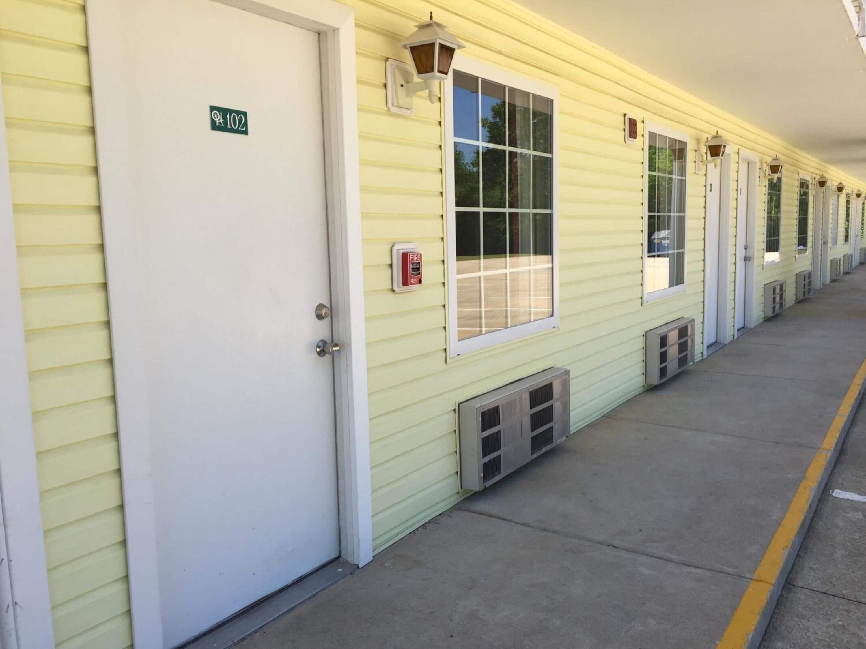 A row of yellow buildings with white doors, each marked with a number.
