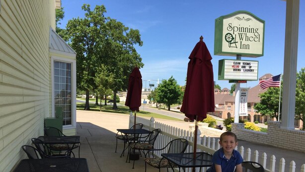 A Spinning Wheel Inn with outdoor seating and a view of the street. - Spinning Wheel Inn Branson (Branson)