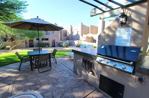 Enjoy al fresco dining on the patio, which features a table, chairs, and a grill.