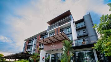 Welcome to The Living Hotel Samut Prakan, featuring a striking entrance with glass and wood elements.