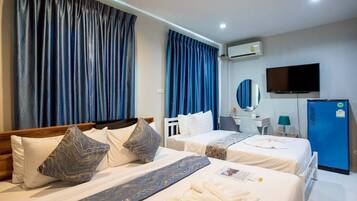 Habitación de hotel con dos camas, un televisor, un refrigerador azul y un equipo de aire acondicionado.