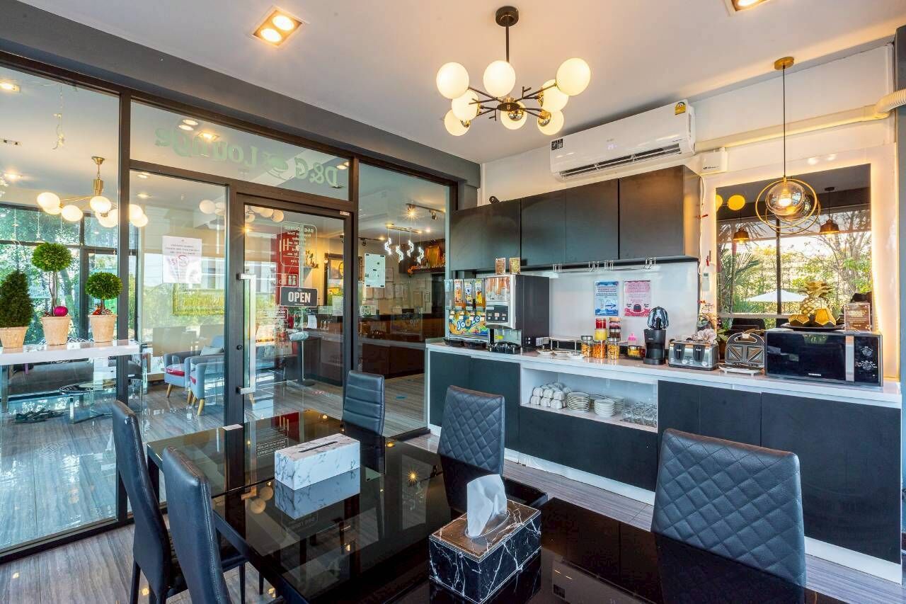 Un restaurante moderno con un mamparo de vidrio, decoración blanco y negro, y diversas opciones de asientos.