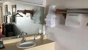 A bathroom with a sink, mirror, towel rack, and a sign that reads "LUNDY". - Twelve Oaks Inn (Branson)