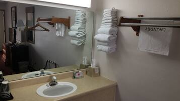 A hotel bathroom with a sink, mirror, towel rack, and a sign that reads "LUNDORY".