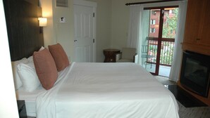 Ein Hotelzimmer mit einem großen Bett, einem Fernseher, einem kleinen Tisch und einem Sessel.