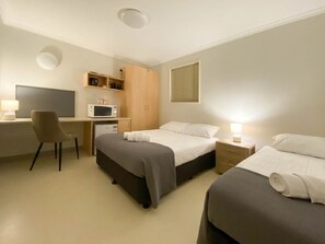 A hotel room with two beds, a desk, a chair, a microwave, and a wardrobe. - Lake Tyrrell Accommodation LTA (Sea Lake)