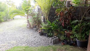 A garden area with various potted plants and a gravel path. - From the beach to golf (Saint-Gilles-les Bains)