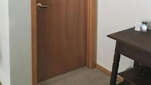 A closed wooden door with a keyhole, a framed picture on the wall, and a small table with a dark surface. - Eagles Watch Ocean Front B and B, Auke Bay, Juneau
 CBJ 1000195 (Juneau)
